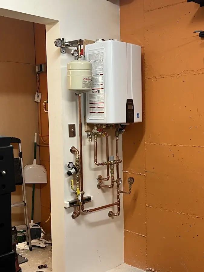 Plumbing technician inspecting water heater connections in University of California-Davis